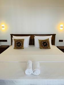 una camera da letto con un letto e due asciugamani di The Nook a Hikkaduwa