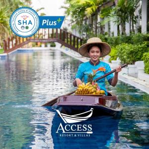 卡隆沙灘的住宿－Access Resort & Villas - SHA Plus，船上的男孩,拿着一捆香蕉