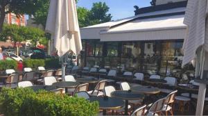 un groupe de tables et de chaises et un parapluie dans l'établissement Beautiful appartement, 20 min to Champs-Elysées, à Maisons-Laffitte