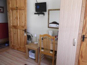 une chambre avec une table, une télévision et une porte dans l'établissement Ashley Lodge Bed & Breakfast, à Rosslare