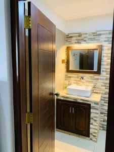 bagno con lavandino e porta in legno di The Nook a Hikkaduwa