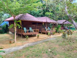 een klein huis met stoelen en een veranda bij Eco Bungalow in Ko Phayam
