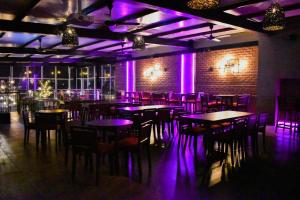a room with tables and chairs and purple lights at THE GRAND CORAL in Bengaluru