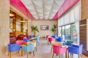 a dining room with colorful chairs and tables at Hotel Grand Efe in Ozdere