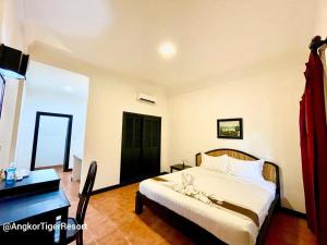 Postel nebo postele na pokoji v ubytování Angkor Tiger Resort