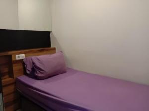 a small bedroom with a purple bed in a room at Raja Apartemen Jarrdin Type 33 in Bandung