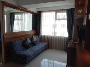 1 dormitorio con cama azul, espejo y ventana en Raja Apartemen Jarrdin Type 33 en Bandung