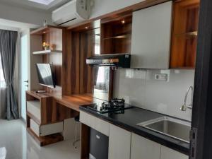 a kitchen with a stove and a sink in it at Raja Apartemen Jarrdin Type 33 in Bandung