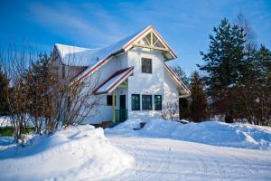 a white house with snow on the ground at Recreational resort Zavidovo in Zavidovo