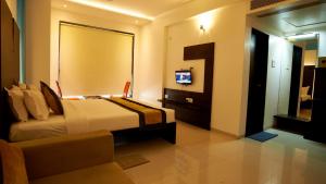 a hotel room with a bed and a television in it at HOTEL SAI NISARG in Shirdi