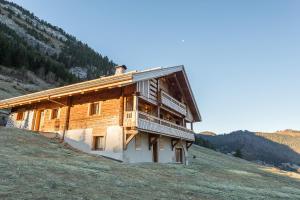 a large wooden building on a hill in a field at Le Lodge Rodzina, Luxueux chalet familial entièrement rénové avec Jacuzzi et Vue par LLA Selections in La Clusaz