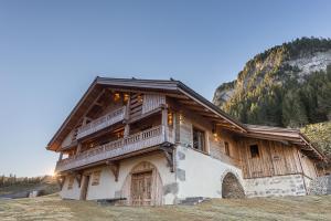Casa de madera con balcones de madera en una montaña en Le Lodge Rodzina, Luxueux chalet familial entièrement rénové avec Jacuzzi et Vue par LLA Selections en La Clusaz
