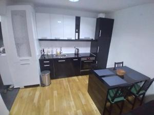 a kitchen with a table and a sink and a dining room at Apartment NM Bjelašnica in Bjelašnica