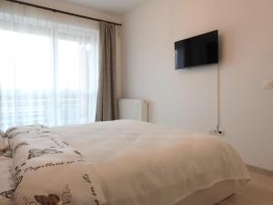 a bedroom with a bed and a flat screen tv at TRUST Apartaments 2 in Braşov