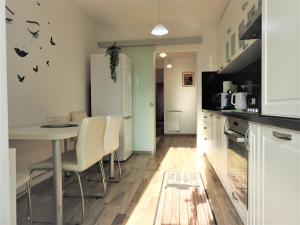 a kitchen with a table and chairs and a refrigerator at TRUST Apartaments 2 in Braşov