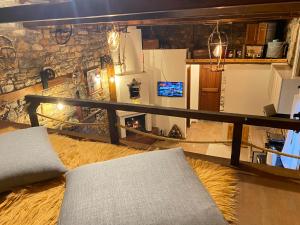 a living room with a couch and a stone wall at FoRest Loft in Tsagarada