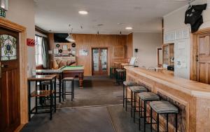 a restaurant with a bar with stools at Hokitika Pioneer Hotel in Hokitika