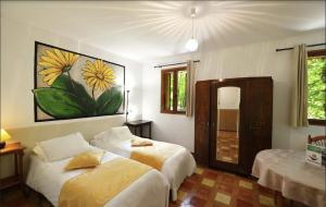 a bedroom with two beds and a painting on the wall at Hotel Monte d'Oro in Vizzavona