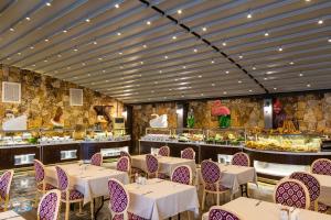 um restaurante com mesas e cadeiras e um bufê em Doğa Thermal Health & Spa em Pamukkale