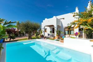a villa with a swimming pool in front of a house at La Ballena Azul CONIL in Cádiz
