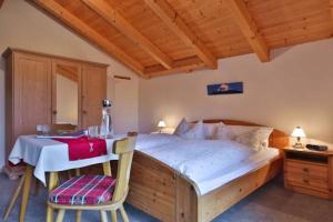 1 dormitorio con 1 cama, mesa y sillas en Haus Almfrieden, en Ramsau