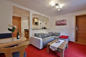 a living room with a couch and a table at Haus Almfrieden in Ramsau