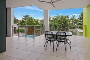 a dining room with a table and chairs on a balcony at Pool View City Centre Apartment 206 in Cairns