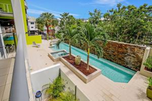 an apartment with a swimming pool and palm trees on a balcony at Pool View City Centre Apartment 206 in Cairns