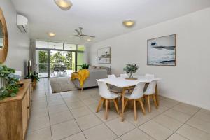 a dining room with a white table and chairs at Pool View City Centre Apartment 206 in Cairns