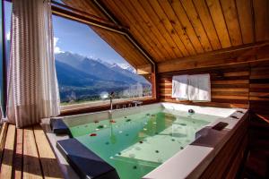 a jacuzzi tub in a room with a large window at The Whitestone Resorts in Manāli