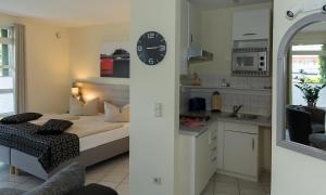 a room with a bed and a kitchen with a clock at Jana´s Ferienappartements in Plau am See