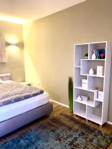 een slaapkamer met een bed en een boekenplank bij Seven in Koblenz
