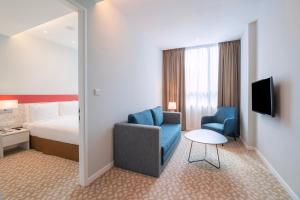 um quarto de hotel com uma cama, uma cadeira e uma mesa em Holiday Inn Express & Suites Johor Bahru, an IHG Hotel em Johor Bahru