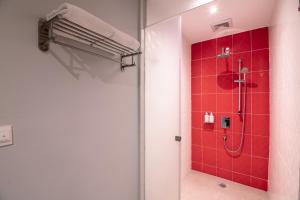ein Bad mit einer Dusche mit roten Fliesen in der Unterkunft Holiday Inn Express & Suites Johor Bahru, an IHG Hotel in Johor Bahru