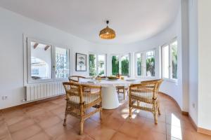 a dining room with a white table and chairs at LA MAR - Managed by Almarina in Benissa