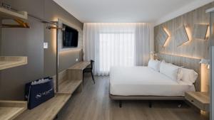 a bedroom with a bed and a desk in a room at Senator Gandia in Gandía