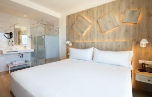 a bedroom with a white bed and a wooden wall at Senator Gandia in Gandía