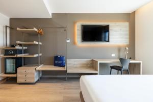 a bedroom with a bed and a tv on a wall at Senator Gandia in Gandía