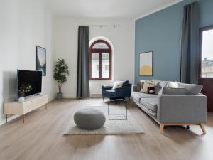 ein Wohnzimmer mit einem Sofa und einem TV in der Unterkunft limehome Dresden Hoyerswerdaerstraße in Dresden