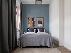 1 dormitorio con 1 cama con paredes azules en limehome Dresden Hoyerswerdaerstraße, en Dresden