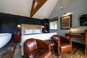 a bedroom with a bed and a bath tub and a bedskirts at Eagle Mill Luxury Rooms in Huntingdon