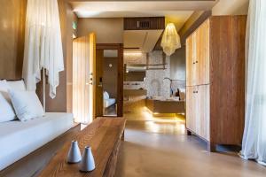 a bedroom with a bed and a wooden table at Skopelos Holidays Hotel & Spa in Skopelos Town