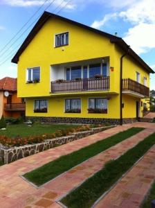 une maison jaune avec un balcon au-dessus dans l'établissement Hekel's privat, à Závažná Poruba