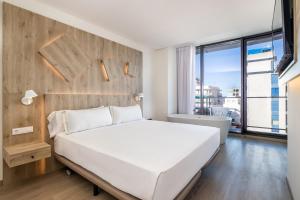 a bedroom with a white bed and a large window at Senator Gandia in Gandía