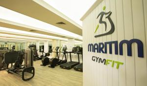 a gym with treadmills and a sign on a wall at Maritim Resort & Spa Mauritius in Balaclava