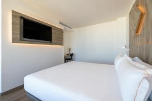 a bedroom with a bed and a tv on a wall at Senator Gandia in Gandía