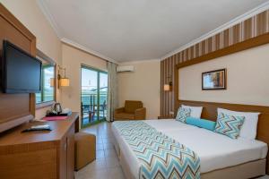 a hotel room with a bed and a television at Iz Flower Side Beach Hotel in Side