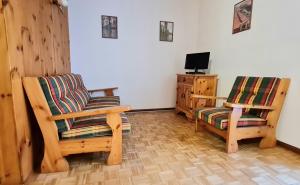 een woonkamer met 2 stoelen en een televisie bij CASA NELLY in Andalo