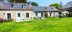 a brick house with a blue door in a yard at Ti Gwen in Plonévez-du-Faou