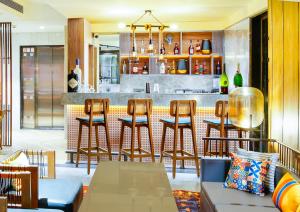 a bar in a restaurant with chairs and a counter at Amoravida By 7 Apple Resorts, Goa in Mandrem
